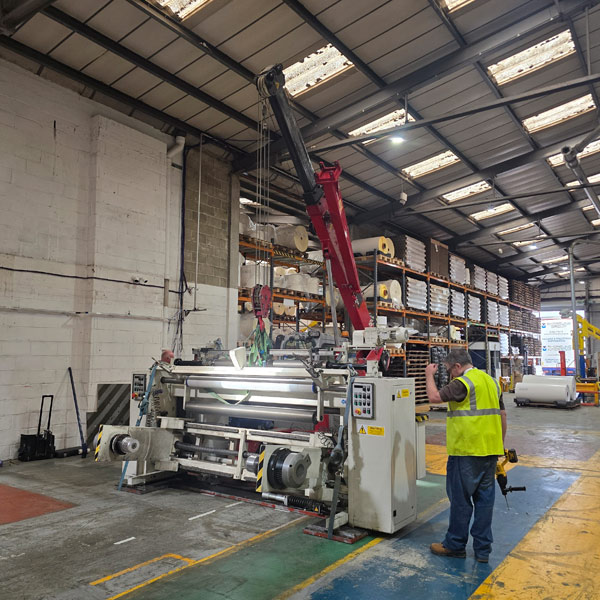 Pick and carry crane lifting 4-ton section of slitting machine at Herma UK factory Newbury