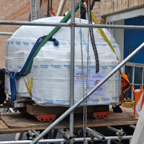 Machine moving team relocating heavy industrial machinery using specialist lifting equipment