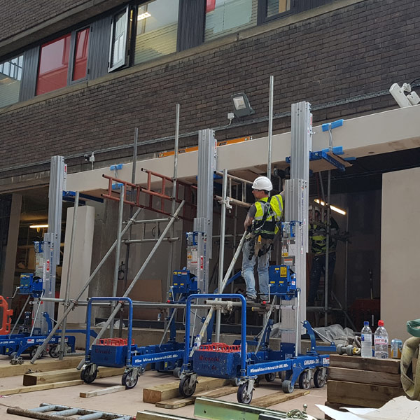 Specialist lifting team positioning precast concrete lintel safely on site