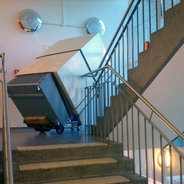 Heavy safe being moved using specialist handling equipment up stairs