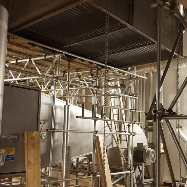 Heavy plate heat exchanger being rotated through factory hopper area